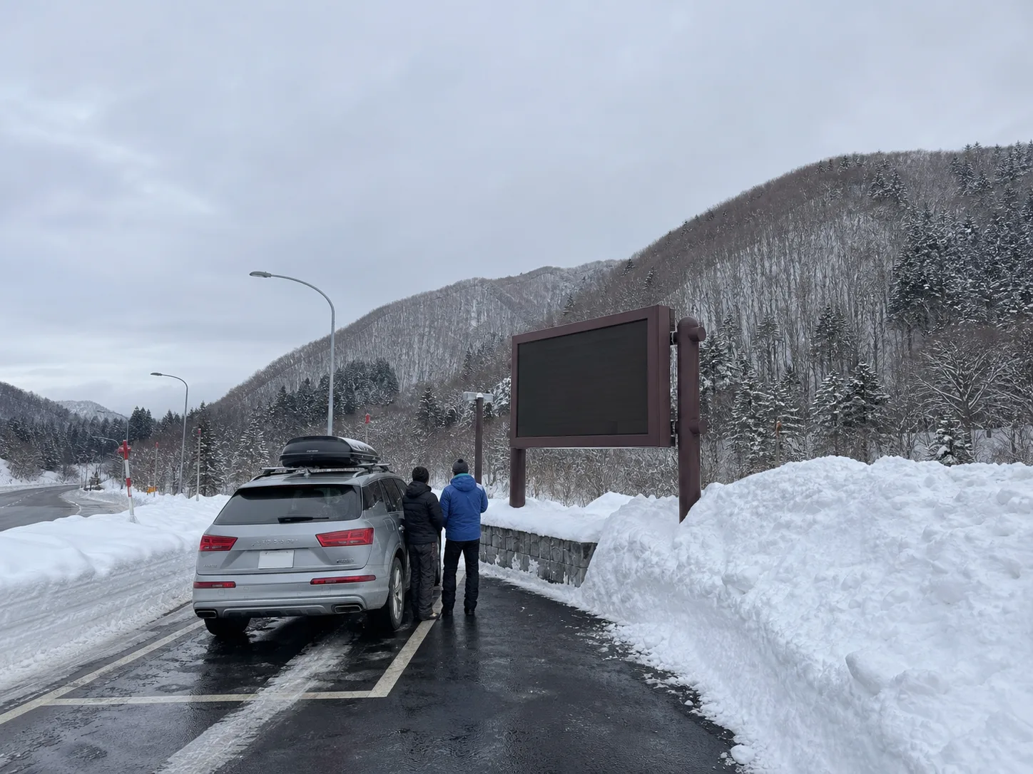 雪の中山峠で道路状況を見ながら休憩するイメージ写真