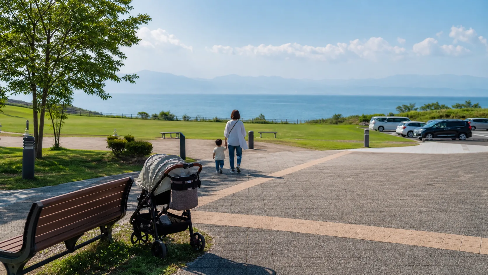 海辺の公園でベビーカーと子どもが休憩するイメージ写真