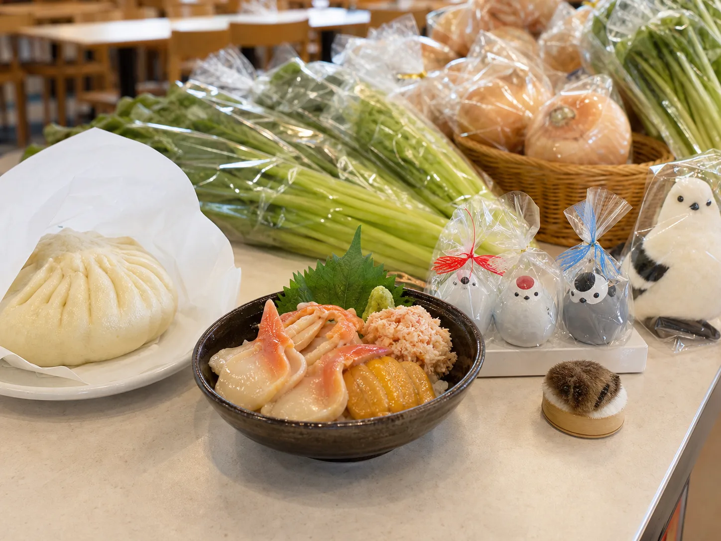苫小牧の海鮮、豚まん、野菜、シマエナガ土産を並べた写真調イメージ
