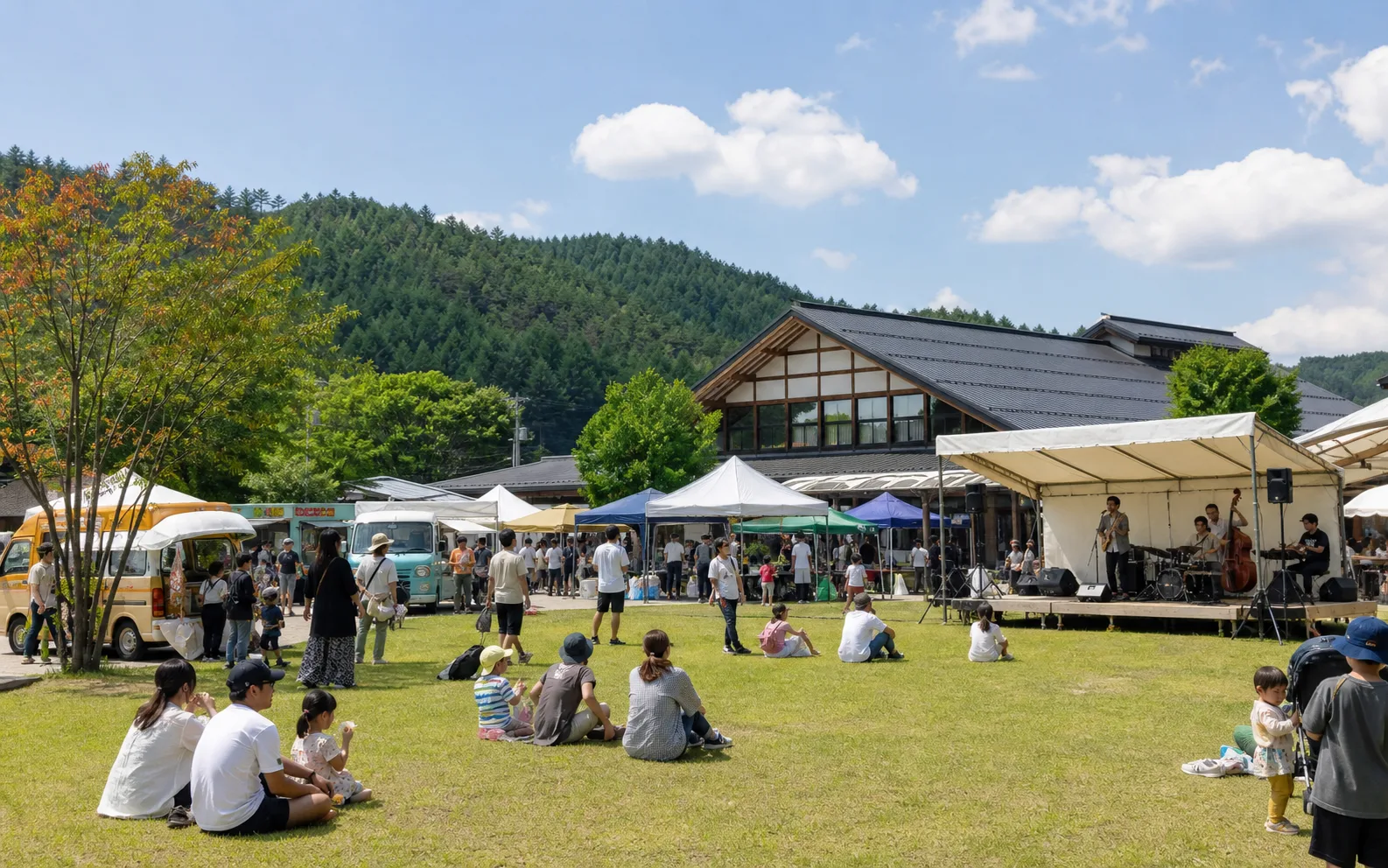 屋外ステージ、マルシェ、キッチンカーが並ぶイベント日のイメージ写真