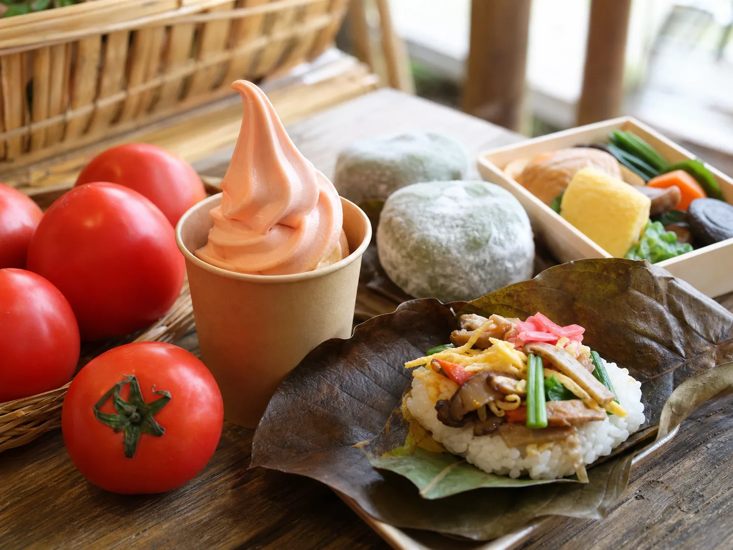 トマト、朴葉寿司、よもぎ大福、軽食を並べた写真調イメージ